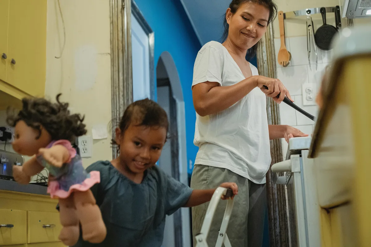 Hispanic single mother cooking with her daughter — the families FineDayFundApply.com serves